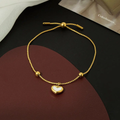 Pulsera dorada de corazón blanco